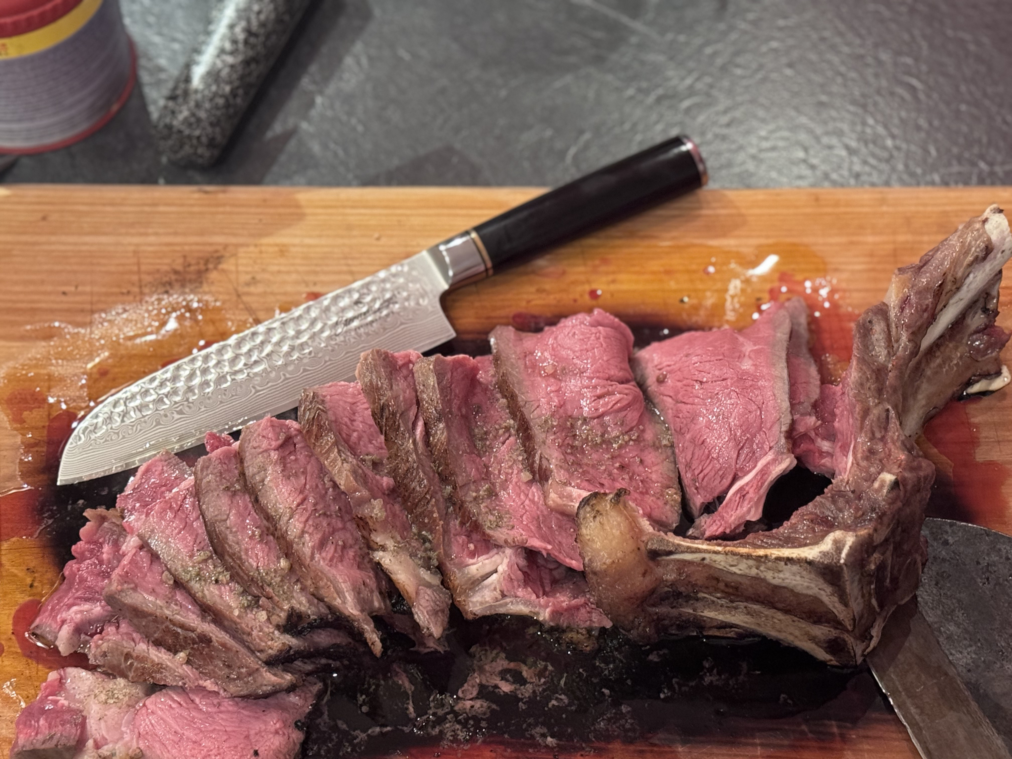 Aufgeschnittenes Tomahawk-Steak mit rosa Kern und knuspriger Kruste